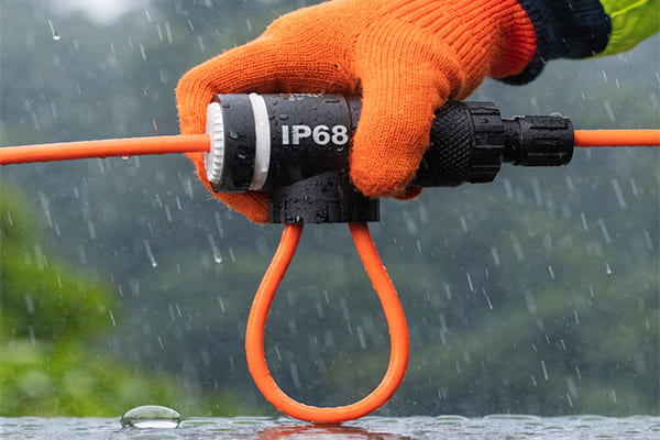 An installer creating a drip loop with an IP68 waterproof connector